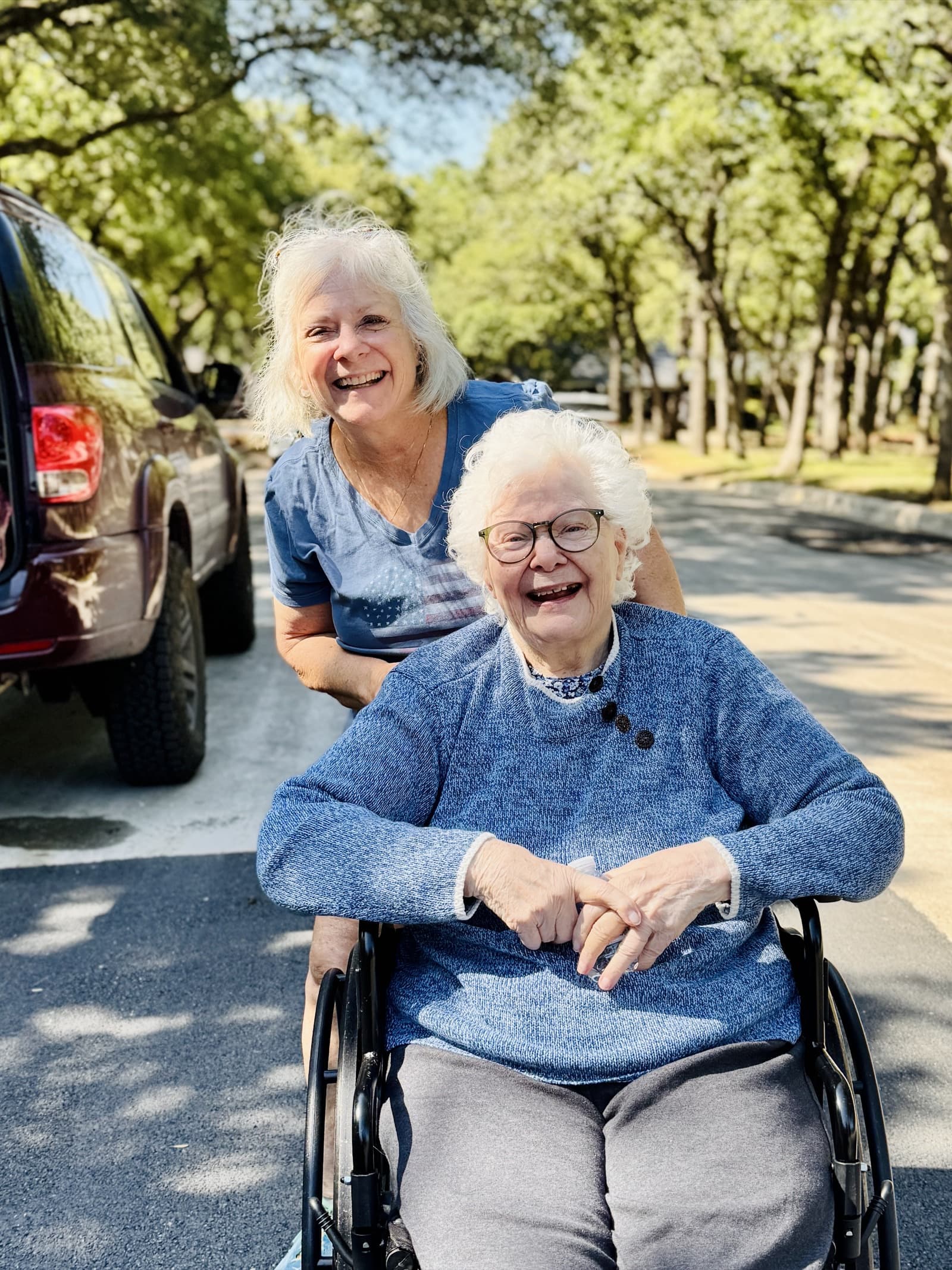 A caregiver and resident enjoying a sunny walk through the neighborhood at Timeless Care Homes
